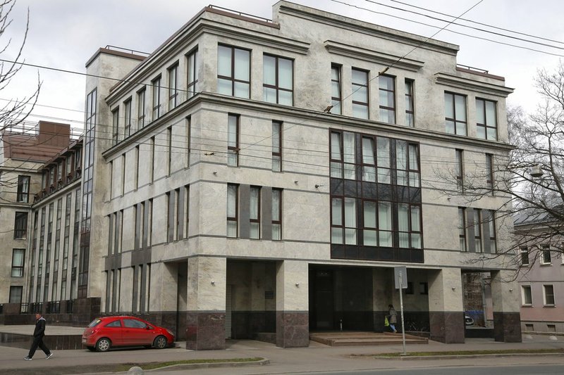 FILE - In this file photo taken on Sunday, April 19, 2015, a women enters the four-storey building known as the "troll factory" in St. Petersburg, Russia.  The U.S. government allege the Internet Research Agency started interfering as early as 2014 in U.S. politics, extending to the 2016 presidential election, saying the agency was funded by a St. Petersburg businessman Yevgeny Prigozhin. 
