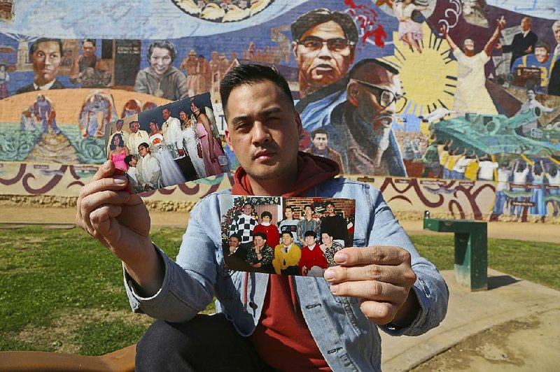 Jeff DeGuia, 28, whose grandfather emigrated from the Philippines, holds up family pictures at Unidad (Unity) Park in Los Angeles.
