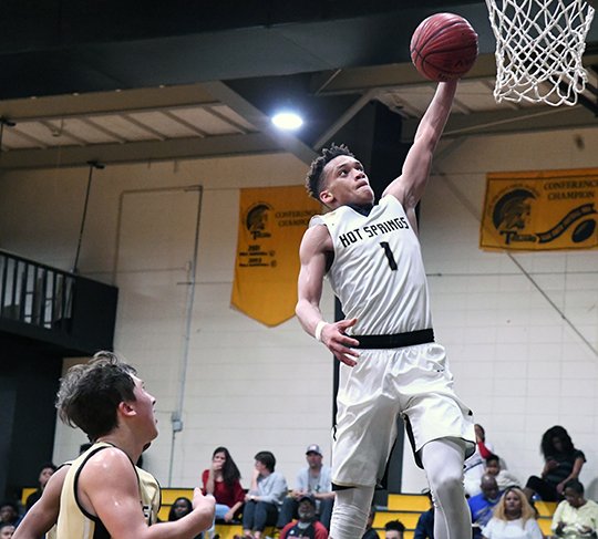 The Sentinel-Record/Grace Brown TOP SEED: Hot Springs' Santiair Thomas (1) rises for a dunk against De Queen's Mack Carver Monday during the Trojans' opening 84-48 victory in the 5A-South conference tournament at Trojan Fieldhouse. Thomas led Hot Springs with 31 points and 12 rebounds.