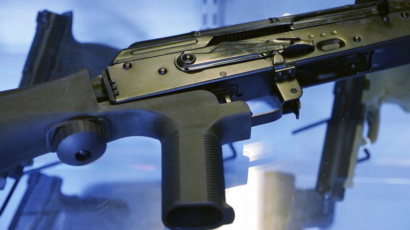 In this Oct. 4, 2017, file photo, a device called a "bump stock" is attached to a semi-automatic rifle at the Gun Vault store and shooting range in South Jordan, Utah. Some states and cities are taking the lead on banning bump stocks as efforts stall in Washington. The controversial device was used in the Las Vegas shooting, allowing a semi-automatic rifle to mimic a fully automatic firearm. Gun-control advocates say the push fits a pattern in gun politics: inaction in Washington that forces states to take charge. 