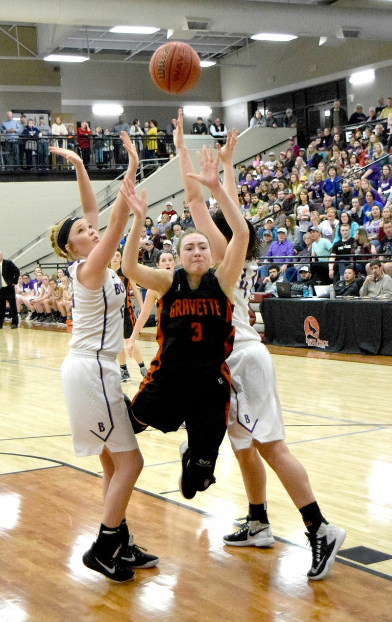 Westside Eagle Observer/MIKE ECKELS Kyrstin Branscum (Gravette 3) loses her balance as she tries to drive between two Berryville players during the championship round of the 1 4A Northwest Conference tournament at Lincoln High School Feb. 17.