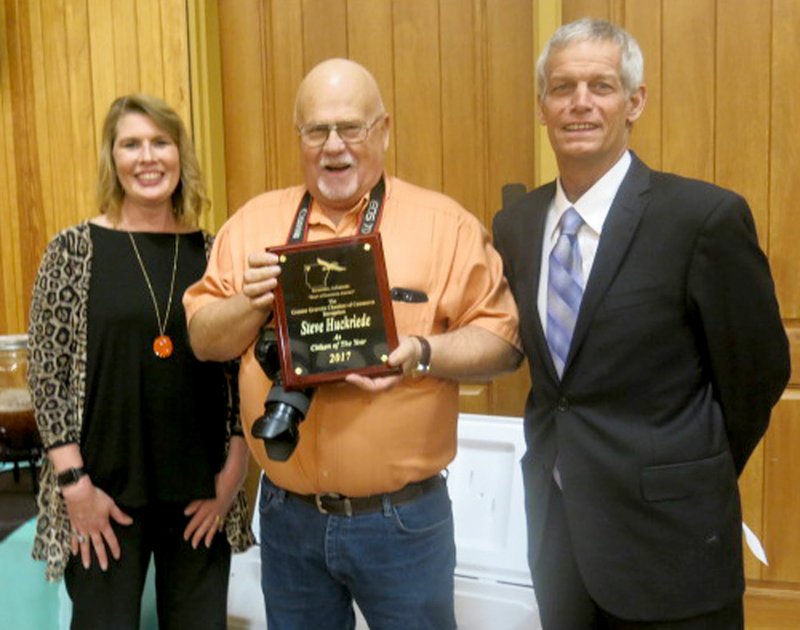 Westside Eagle Observer/SUSAN HOLLAND Steve Huckriede (center), displays the plaque he received honoring him as Gravette Citizen of the Year at the Greater Gravette Chamber of Commerce banquet Thursday, Feb. 15. Steve, who operates Steve Huckriede Photography, is serving his second term as GGCC secretary. He is pictured with Sundee Hendren, Chamber treasurer, and Fred Overstreet, Chamber president.