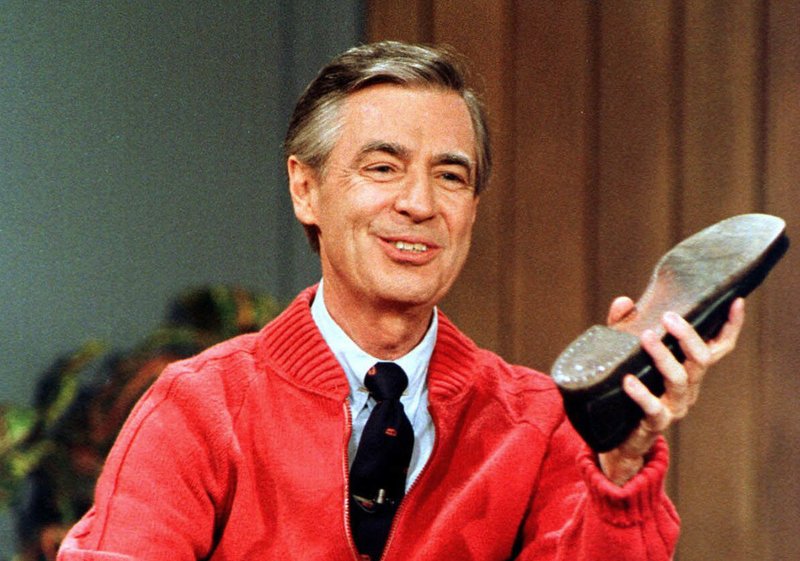 FILE - This June 28, 1989, file photo, shows Fred Rogers as he rehearses the opening of his PBS show "Mister Rogers' Neighborhood" during a taping in Pittsburgh. It's been 50 years since Fred Rogers first appeared on our TVs, a gentle and avuncular man who warbled "Won't You Be My Neighbor?" The golden anniversary of America's favorite neighbor's appearance is being celebrated with a PBS special next month, a new stamp, a feature-length documentary coming out this summer and plans for a Tom Hanks-led biopic. (AP Photo/Gene J. Puskar, File)