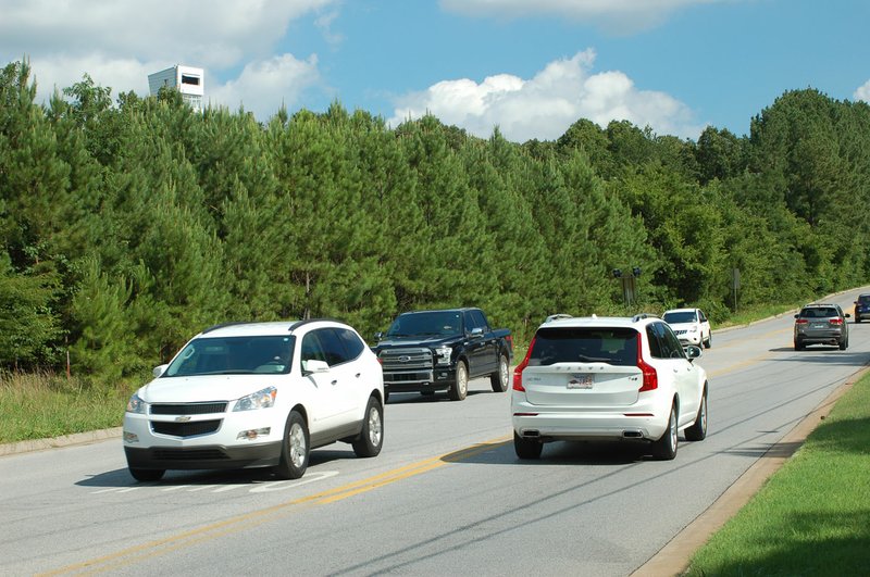 NWA Democrat-Gazette/FILE PHOTO Cars move along Old Missouri Road near the dead-end intersection with Rolling Hills Drive in Fayetteville on July 6.