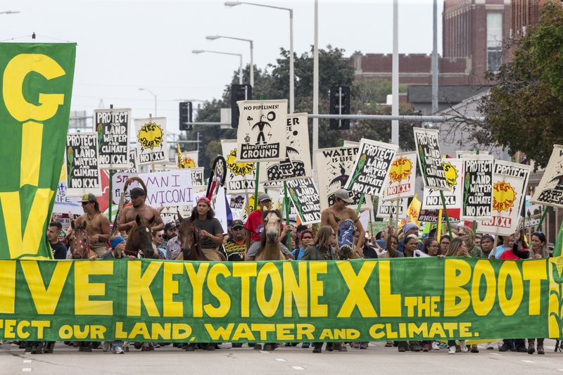 FILE--In this Aug. 6, 2017, file photo, demonstrators against the Keystone XL pipeline march in Lincoln, Neb. Opponents of the proposed oil pipeline from Canada are asking a federal judge to force the U.S. government to turn over emails and other documents related to President Donald Trump's approval of the project. (AP Photo/Nati Harnik, file)