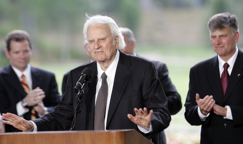 FILE - In this May 31, 2007 file photo, Billy Graham speaks as his son Franklin Graham, right, listens during a dedication ceremony for the Billy Graham Library in Charlotte, N.C.. Graham, who transformed American religious life through his preaching and activism, becoming a counselor to presidents and the most widely heard Christian evangelist in history, has died. Spokesman Mark DeMoss says Graham, who long suffered from cancer, pneumonia and other ailments, died at his home in North Carolina on Wednesday, Feb. 21, 2018. He was 99.(AP Photo/Gerry Broome)

