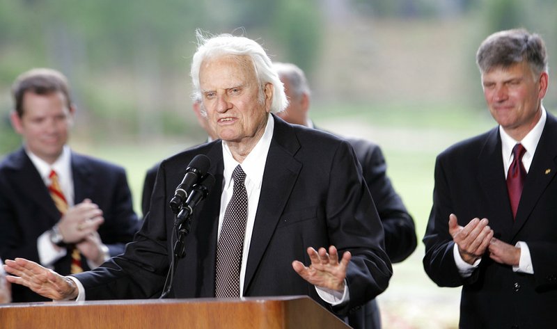 In this May 31, 2007 file photo, Billy Graham speaks as his son Franklin Graham, right, listens during a dedication ceremony for the Billy Graham Library in Charlotte, N.C..  Graham, who transformed American religious life through his preaching and activism, becoming a counselor to presidents and the most widely heard Christian evangelist in history, has died. Spokesman Mark DeMoss says Graham, who long suffered from cancer, pneumonia and other ailments, died at his home in North Carolina on Wednesday, Feb. 21, 2018. He was 99.