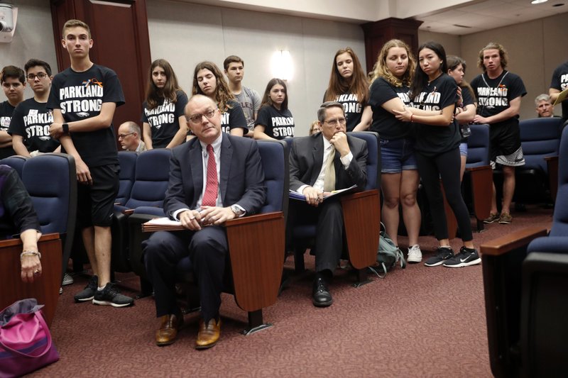 Lobbyists and attorneys listen as student survivors from Marjory Stoneman Douglas High School, where more than a dozen students and faculty were killed in a mass shooting on Wednesday, interrupt a house legislative committee hearing, to challenge lawmakers on gun control reform, in Tallahassee, Fla., Wednesday, Feb. 21, 2018. 