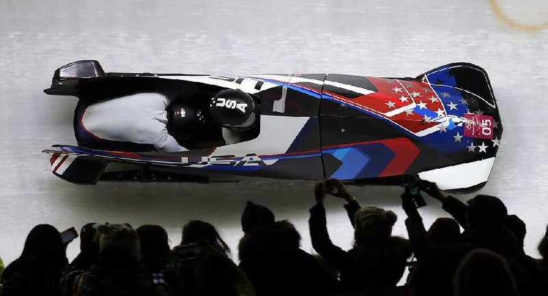 Fans watch as Americans Elana Meyers Taylor (front) and Lauren Gibbs streak past during their final run in women’s two-man bobsled Wednesday at the Alpensia Sliding Centre in Pyeongchang, South Korea. Taylor and Gibbs won the silver medal in the event.  
