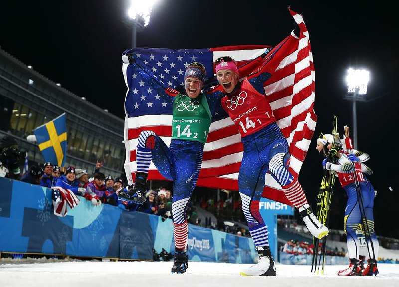 Jessica Diggins (left) and Kikkan Randall of the United States celebrate after winning the gold medal in the women’s team sprint freestyle cross-country skiing event Wednesday. It was the first time Americans have earned a cross-country skiing medal since 1976. 
