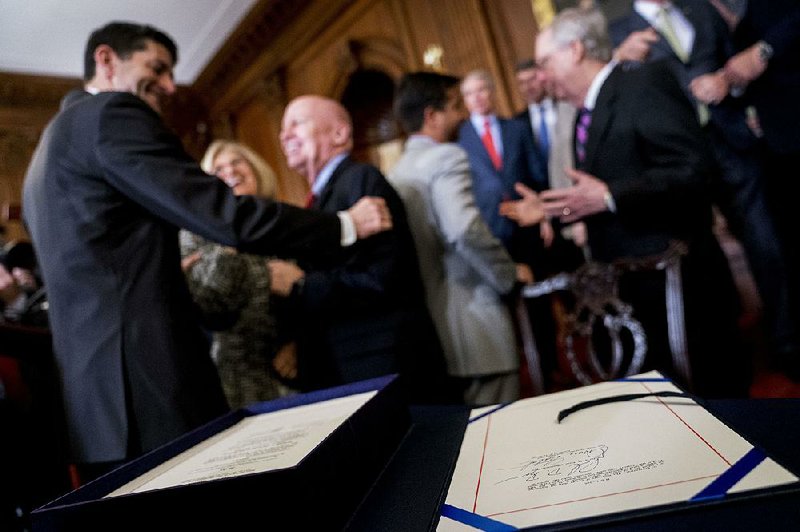 The signatures of Speaker of the House Paul Ryan, R-Wis., and Senate Finance Committee Chairman Orrin Hatch, R-Utah, on the final version of the GOP tax bill appear in the foreground at a ceremony in December. 
