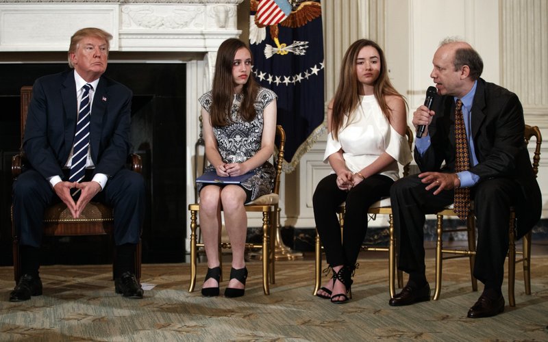 From left, President Donald Trump, Marjory Stoneman Douglas High School student students Carson Abt, and Ariana Klein, listen as Carson's father Frederick Abt, speaks during a listening session with high school students, teachers, and others in the State Dining Room of the White House in Washington, Wednesday, Feb. 21, 2018.  (AP Photo/Carolyn Kaster)

