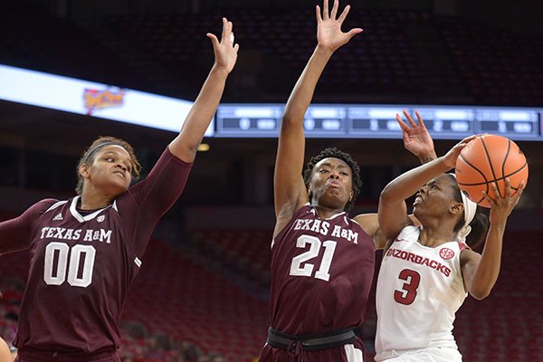 Arkansas' Malica Monk (3) attempts a shot in the lane as Texas A&M's Jasmine Lumpkin (21) and Khaalia Hillsman (00) defend Thursday, Feb. 22, 2018, during the second half in Bud Walton Arena.
