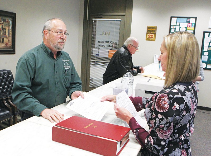 The Sentinel-Record/Richard Rasmussen FILING PERIOD OPENS: Garland County Treasurer Tim Stockdale, left, files his paperwork with County Clerk Sarah Smith Thursday to run in the May primaries. He and Smith both filed for re-election on the opening day of the weeklong filing period.