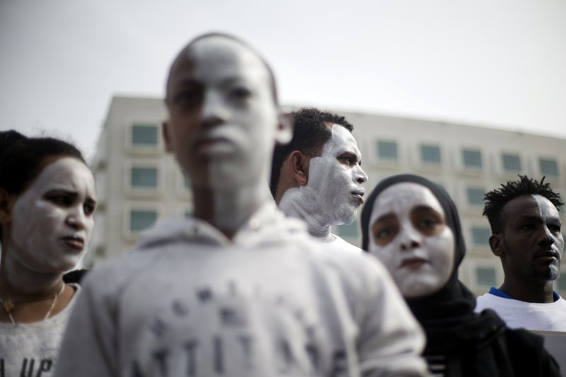 In this Wednesday, Feb. 7, 2018 photo, African migrants chant slogans during a protest in front of the Rwanda embassy in Herzeliya, Israel. Tens of thousands of African asylum seekers, nearly all from dictatorial Eritrea and war-torn Sudan, fear their stay in Israel is coming to an abrupt end. The Israeli government has given them until April 1 to leave the country for an unnamed African destination -- known to be Rwanda -- in exchange for $3,500 and a plane ticket, or they will be incarcerated indefinitely. (AP Photo/Ariel Schalit)