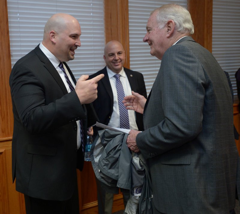 NWA Democrat-Gazette/ANDY SHUPE Jay Dostal (left), newly hired high school principal, speaks Thursday with interim principal Steve Jacoby during a meeting of Fayetteville's School Board at Fayetteville High School. Dostal will assume his duties July 1.