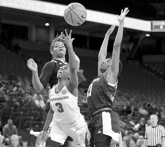 NWA Democrat-Gazette/Andy Shupe SHOT ATTEMPT: Arkansas’ Malica Monk (3) attempts a shot in the lane as Texas A&M’s Jasmine Lumpkin (21) and Khaalia Hillsman (00) defend Thursday during the second half of the Razorbacks’ 104-60 loss Bud Walton Arena in Fayetteville.