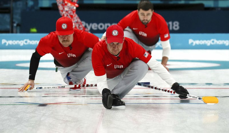 United States's skip John Shuster, center, slides on the ice with teammates before the start of the their men's curling match against United States at the 2018 Winter Olympics in Gangneung, South Korea, Sunday, Feb. 18, 2018. 