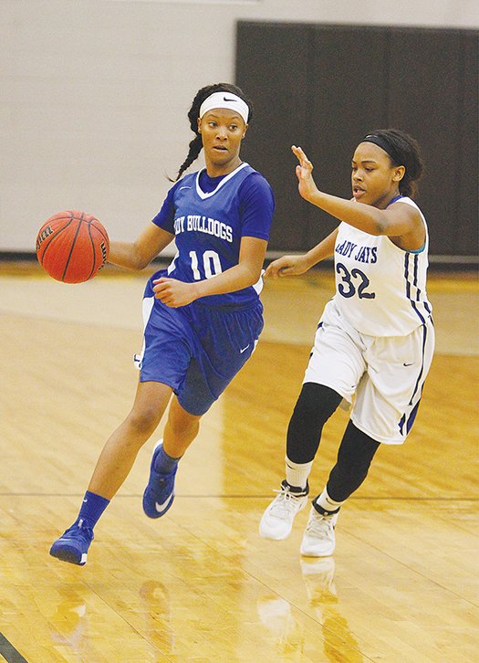 Terrance Armstard/News-Times  Strong's Kiki Shelton (10) brings the ball up the court as Nevada's Jayden Riley (32) defends during the first half of their game at the 5-1A Regional Tournament in Hampton Thursday.