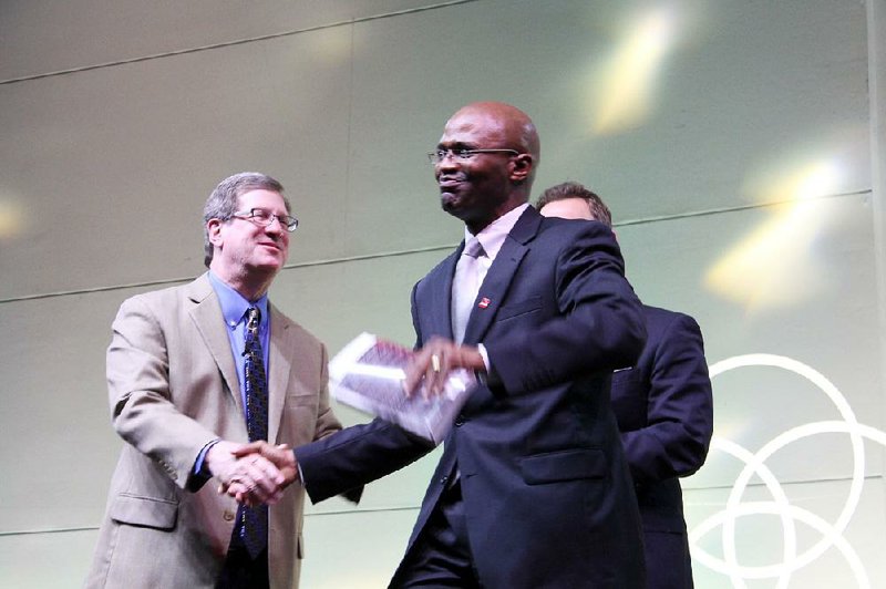 Scott McLean (center) shakes hands with Lee Strobel (left) as he accepts a signed copy of Strobel’s The Case for Christ. Proceeds from the ticket sales for the second City Center Conversations event hosted by Immanuel Baptist Church in Little Rock will be donated to the prison ministry and re-entry program Pathway to Freedom, which McLean heads.

