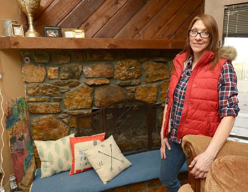 Melissa Hill poses Thursday, Feb. 1, 2018, next to the fireplace in her favorite space, the living room of her Fort Smith home.