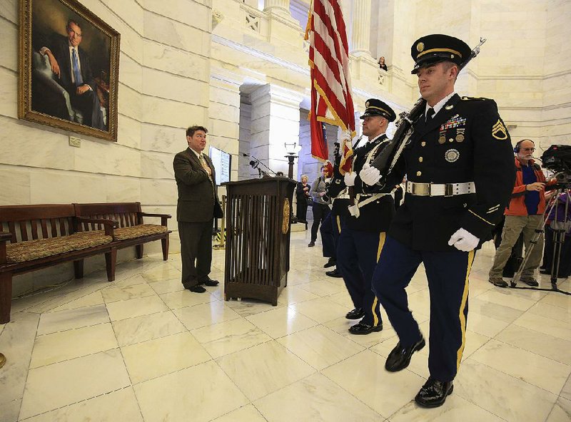 Secretary of State Mark Martin (left) places his hand over his heart Thursday in the state Capitol rotunda as an Arkansas National Guard honor guard presents the colors before Martin officially declared the opening of the candidate filing period.