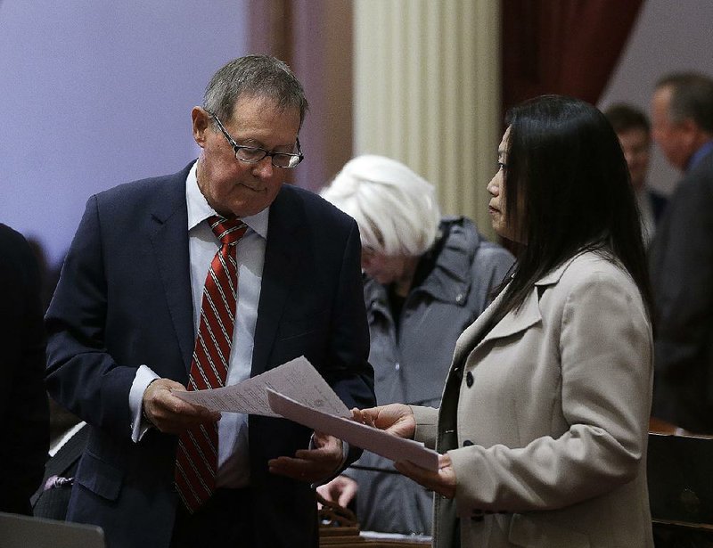 State Sen. Janet Nguyen hands Sen. Tom Berryhill a copy of Sen. Tony Mendoza’s letter of resignation on Thursday in Sacramento, Calif.  