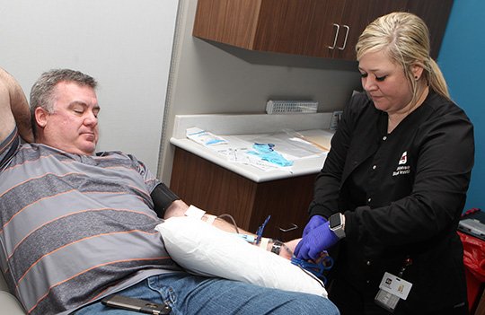 The Sentinel-Record/Richard Rasmussen URGENT NEED: Apheresis technician Alexandra Mason, right, works with donor Greg Robbins at the Arkansas Blood Institute on Friday. ABI is asking donors of all blood types to give as soon as possible due to a winter storm that affected Oklahoma this week.