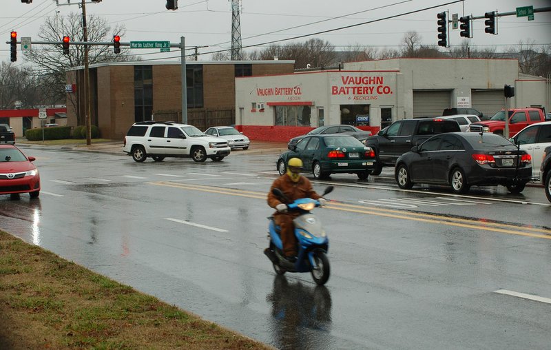 A motorist scoots by near the intersection of Martin Luther King Jr. Boulevard and School Avenue on Friday in Fayetteville. Experts with the Urban Land Institute held a panel discussion on the future of the College Avenue/U.S. 71B corridor.