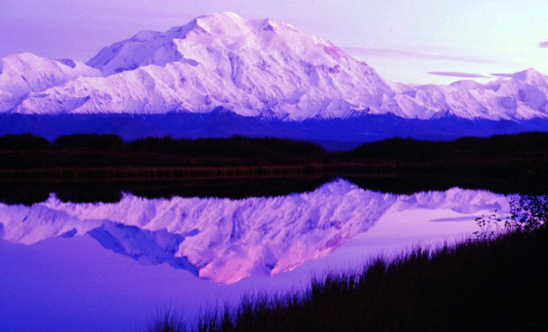 FILE - In this undated file photo, the sun sets as Mount McKinley casts its reflection on Reflection Pond at the west end of Denali National Park Road in Denali Park, Alaska. US Interior Department Secretary Ryan Zinke said Friday, Feb. 23, 2018, that he wants to reorganize the agency that oversees vast public lands and energy resources in the West. (AP Photo/Al Grillo, File)