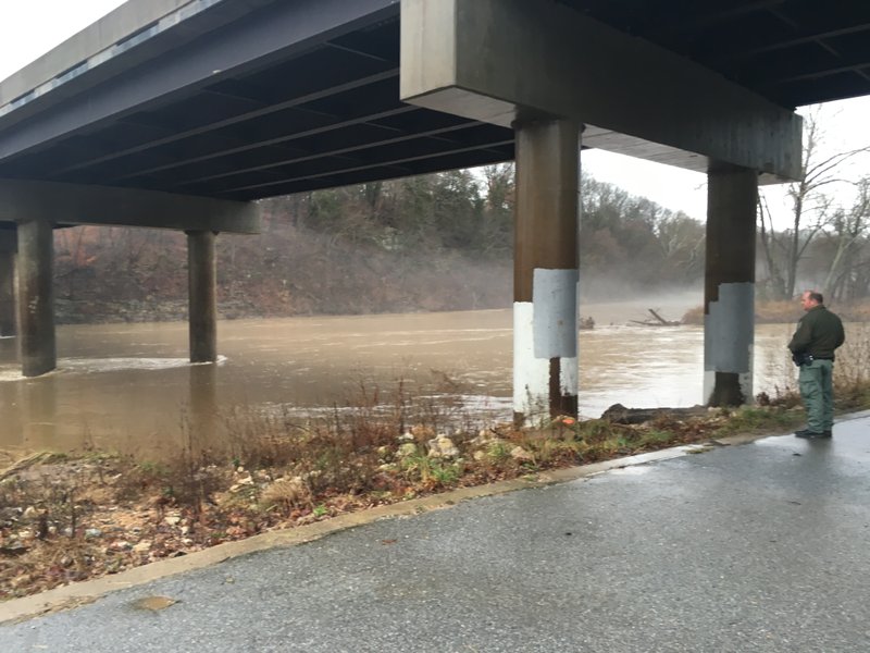 Clayton Hungate, and officer with the Arkansas Game and Fish Commission, examines the White River.