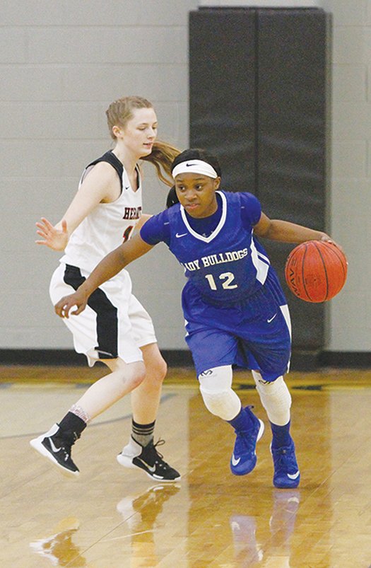 Terrance Armstard/News-Times Strong's Dynasty Davis (12) goes around Hermitage's Haley Raney (10) during the first half of their game at the 5-1A Regional Tournament in Hampton Friday. The Lady Bulldogs upended Hermitage 46-44 to advance to the finals.