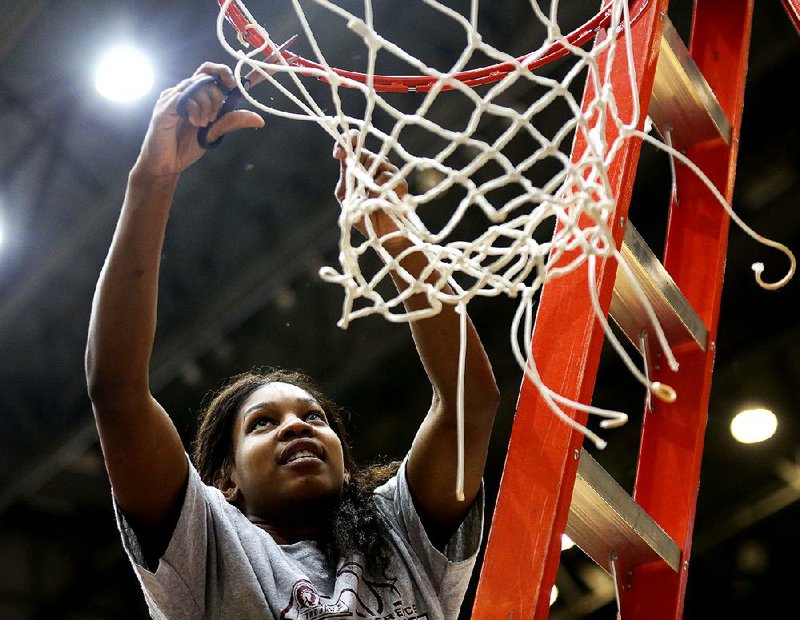UALR’s Monique Townson cuts down the net after the Trojans clinched the Sun Belt Conference title with Saturday’s victory over Appalachian State.