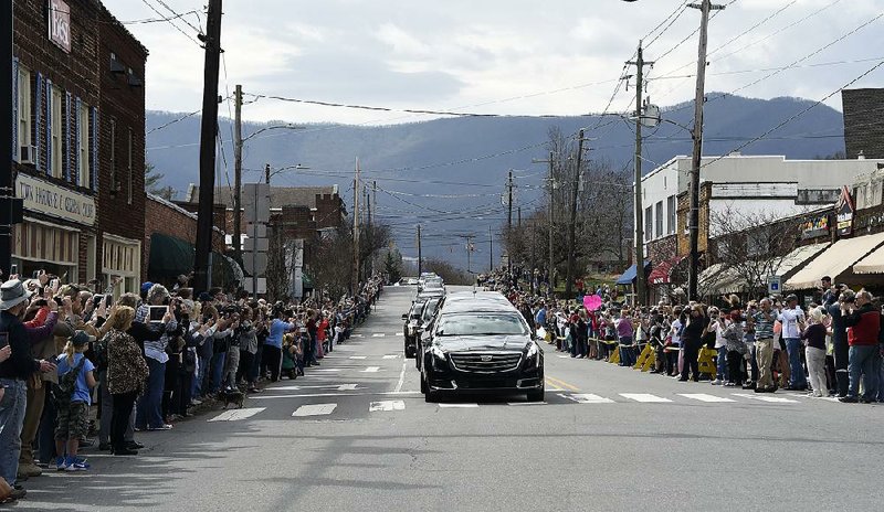 People line the street Saturday to pay respects as the hearse carrying the body of the Rev. Billy Graham travels through Black Mountain, N.C. 