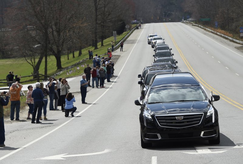 People line the street as the hearse carrying the body of Rev. Billy Graham leaves the Billy Graham Training Center at the Cove on Saturday, Feb. 24, 2018 in Asheville, N.C. Graham's body will be brought to his hometown of Charlotte on Saturday as part of a procession expected to draw crowds of well-wishers. (AP Photo/Kathy Kmonicek, Pool)