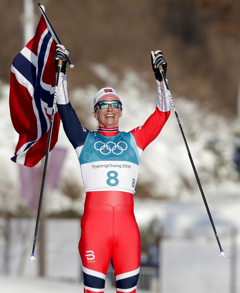 Marit Bjoergen, of Norway, celebrates after winning the gold medal in the women's 30k cross-country skiing 