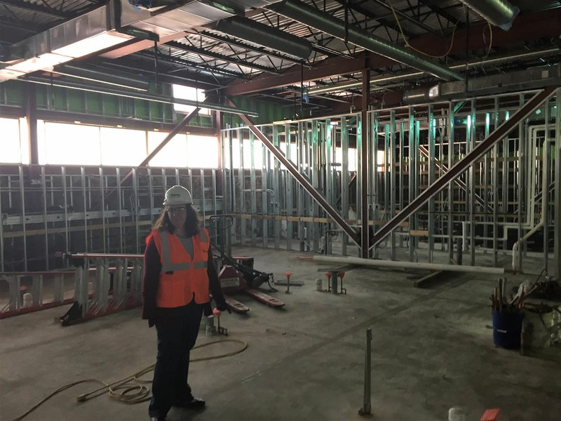 NWA Democrat-Gazette/DAVE PEROZEK Heather Wright, high school principal at the Arkansas Arts Academy, takes a tour of a building under construction on her school's campus Feb. 15. The building is set to open to students in August.