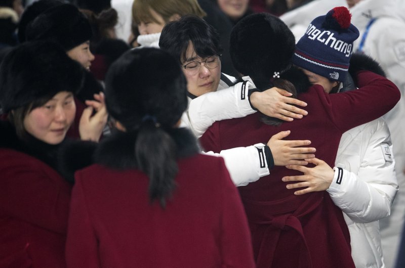 A North Korean women's hockey team player hugs her South Korean teammates, wearing white coats, before returning to North Korea, at Olympic Village in Gangneung, South Korea, Monday, Feb. 26, 2018. (Yun Dong-jin/Yonhap via AP)