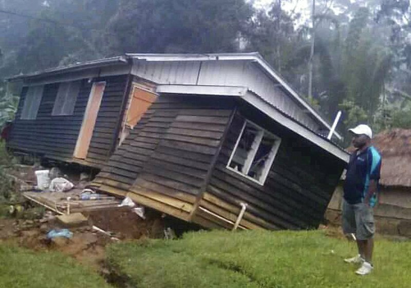 A man views a house that collapsed in a strong earthquake Tuesday, Feb. 27, 2018, in Halagoli, Hela Province, Papua New Guinea. 