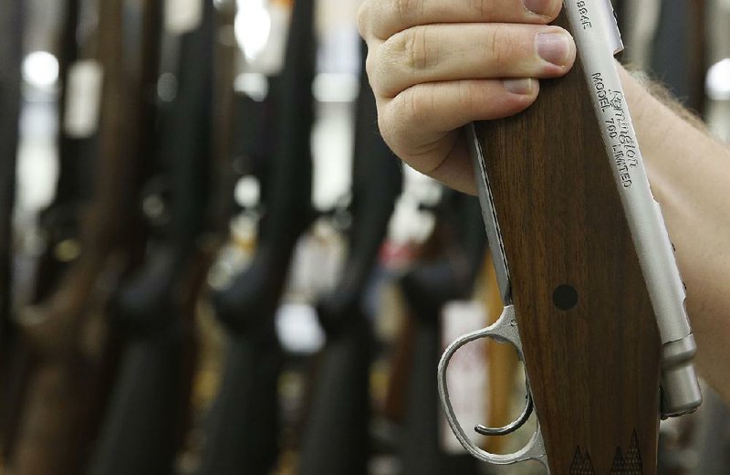 A shopper holds a Remington rifle at a gun store in Orem, Utah, in this 2016 photo.