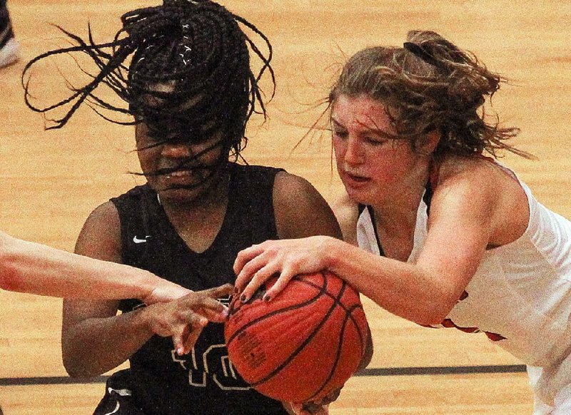 De Queen’s Tatyana Tramble (left) and Farmington’s Alexis Roach fight for a loose ball during Tuesday’s first-round game at the Class 5A girls state tournament at Maumelle High School. 