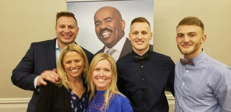 Nathan Kirby (left) poses with a poster of Family Feud host Steve Harvey while auditioning for the show with (from left): Renee Luers-Gillispie and Tiffany, Colton and Ashton Kirby.