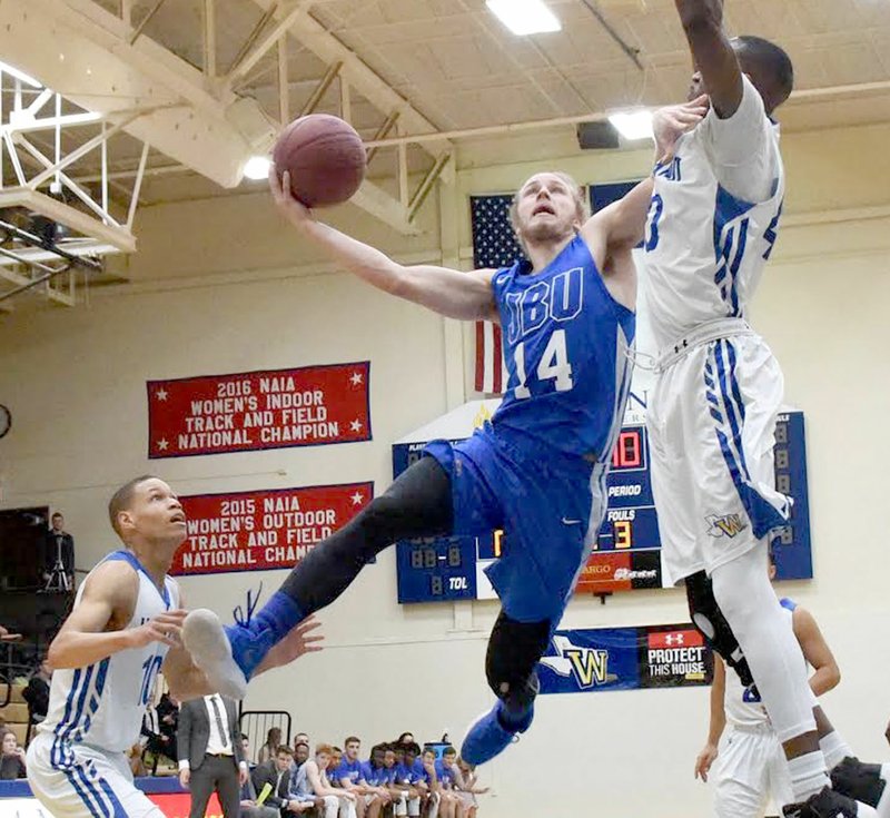 Photo courtesy of Wayland Baptist John Brown junior guard Jake Caudle takes the ball to the rim as Wayland Baptist's Samuel Kalwanyi defends on the play during Saturday's game in Plainview, Texas.