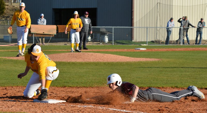 Mike Capshaw/Herald-Leader Siloam Springs' Taylor Pool slides back into first base on a pick-off attempt after his leadoff single in the first inning of the Panthers' 13-2 victory at Prairie Grove on Monday. Pool finished 3-for-4 with two RBIs to lead the Panthers' 10-hit attack.