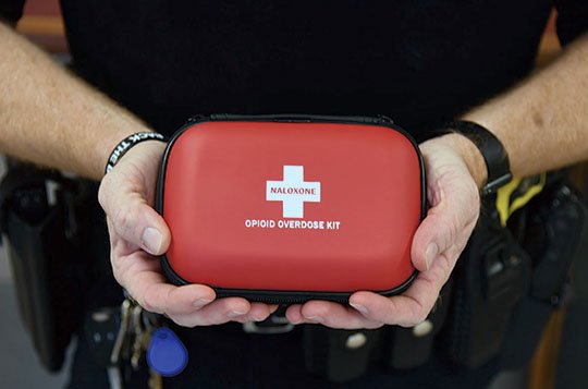 The Sentinel-Record/Grace Brown LIFESAVER: Hot Springs police Officer 1st Class Joey Williams holds up a Naloxone Opioid Overdose Kit at the Hot Springs Police Department on Tuesday. Thanks to a grant, first responders in Garland County will be issued kits with two doses of the lifesaving medication.
