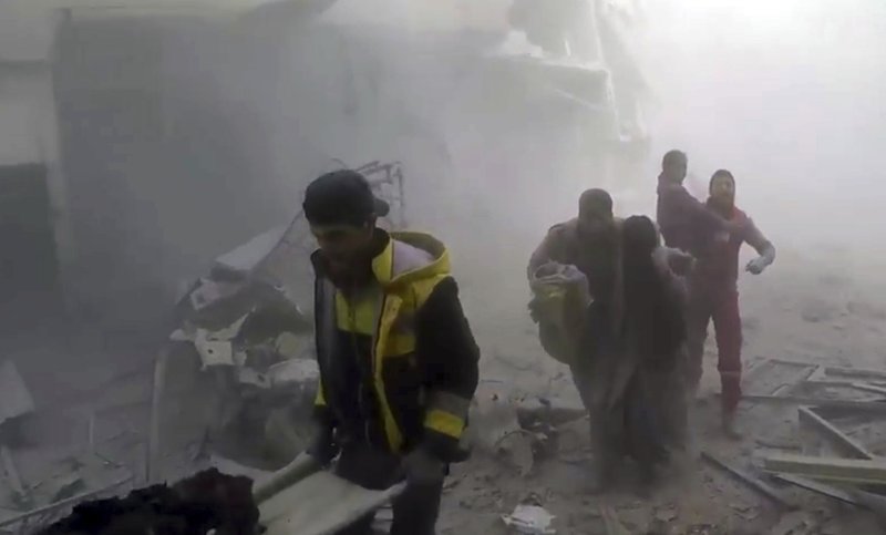 This frame grab from video released on Saturday, Feb 24, 2018 by the Syrian Civil Defense group known as the White Helmets, shows members of the Syrian Civil Defense group help residents during airstrikes and shelling by Syrian government forces, in Ghouta, a suburb of Damascus, Syria. A new wave of airstrikes and shelling on eastern suburbs of the Syrian capital Damascus left at least 22 people dead and more than a dozen wounded Saturday, raising the death toll of a week of bombing in the area to nearly 500, including scores of women and children. (Syrian Civil Defense White Helmets via AP)