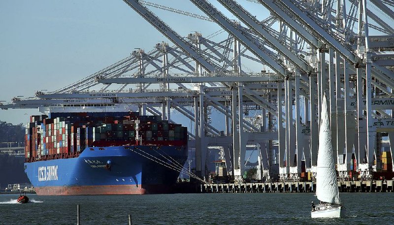 A container ship waits to be unloaded in January at the Port of Oakland in California. The Commerce Department reported Wednesday that the U.S. economy’s rate of growth slowed in the last three months of 2017. 