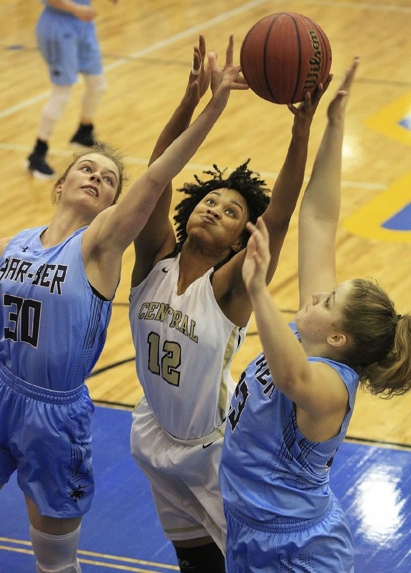 Little Rock Central’s Mikelle Cole (center) reaches for a rebound between Springdale Har-Ber’s Sophie Nelson (left) and Sophie Wood during Wednesday’s game at the Class 7A girls state tournament in North Little Rock. See more photos at arkansasonline.com/galleries.
