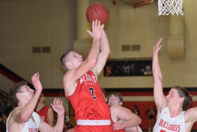 RICK PECK/SPECIAL TO MCDONALD COUNTY PRESS McDonald County's Peyton Barton goes to his left hand for a basket during the Mustangs' 64-55 loss to Carl Junction on Feb. 22 at Carl Junction High School.