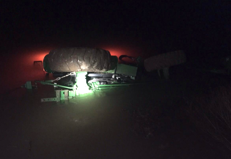 This photo provided by the Baxter County sheriff's office shows a tractor partially submerged in a pond it slid off a levee Wednesday.